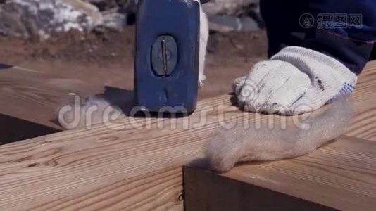 在搭建模板时，用均匀的白手套和白手套将木梁锤起。 剪辑。 男工视频