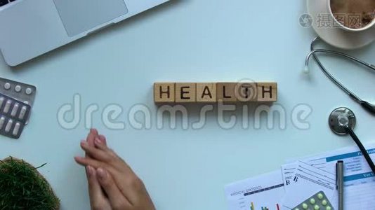 健康单词：桌子上的木立方体，医生拿着玩具心脏，捐献者视频