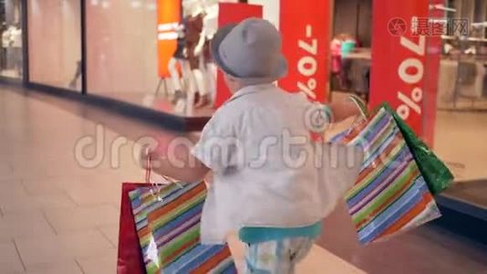 时尚购物，在昂贵的精品店购买后，顾客手拿包裹穿过购物中心视频