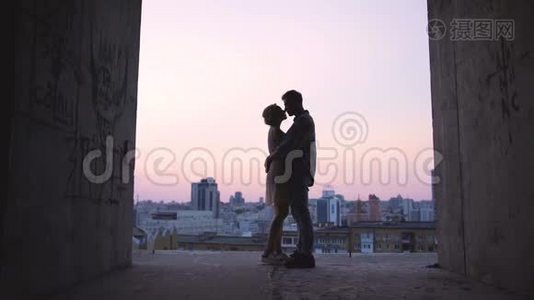 在地平线上夕阳的背景下拥抱恋人的剪影，浪漫视频