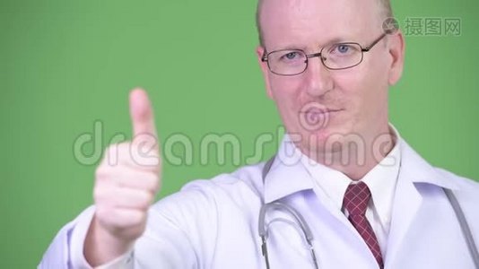 快乐成熟的秃头医生一边竖起大拇指一边思考视频