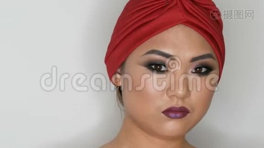 高级时尚，一位美丽的亚洲女孩模特的肖像，她身着红色头巾，身着鲜艳的化妆视频