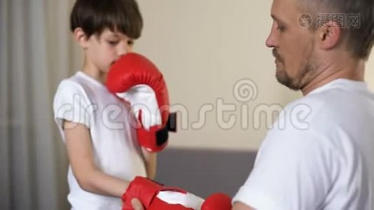 慈爱的父亲戴上儿子的双臂拳击手套，教自己如何自卫视频