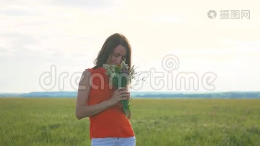 美丽的女孩，田野的花站在草地上。视频