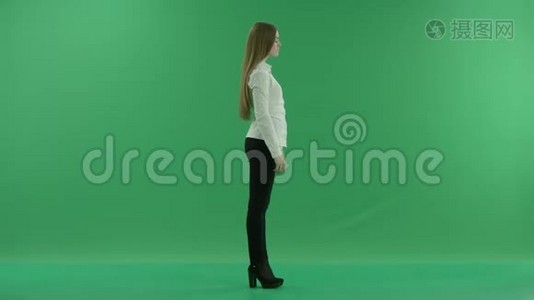 惹人厌烦的年轻商务女性正在用手机说话，站在绿色屏幕的中央，全身而退视频