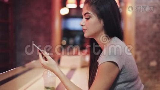 美女在夜酒吧用智能手机说话，听语音留言。 享受夜生活的女人视频