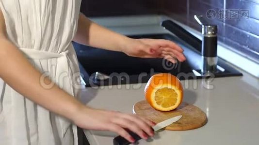 女孩用刀切橘子。 健康的生活方式观念。视频