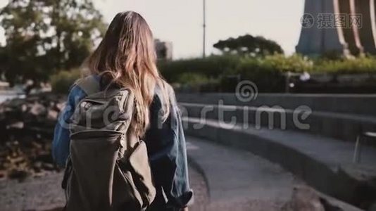 镜头跟随美丽的白种人女游客背着背包漫步在布鲁克林公园混凝土河岸慢动作视频