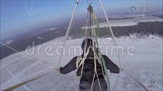 空中滑翔机在阳光明媚的天空中飞过白雪覆盖的草地视频