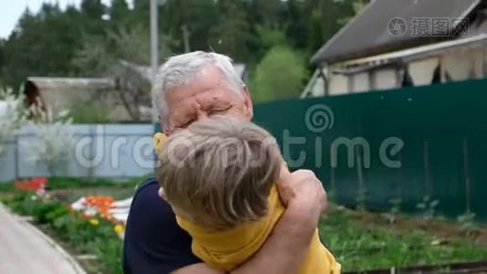 可爱的小男孩拥抱他的祖父，夏天在户外视频