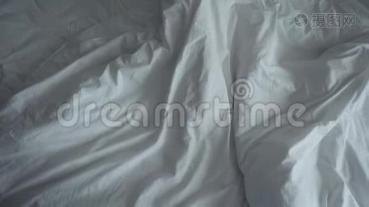 不整洁的皱巴巴的床和白色的床上用品。视频