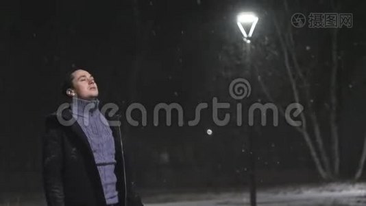 街灯里的那个人。 `在灯的背景下下雪。 在180fps内缓慢运动.. 雪花真美视频