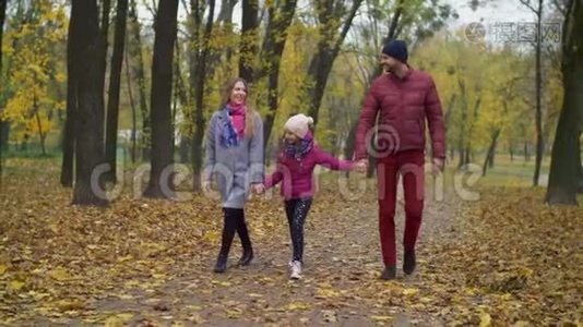 与女孩在秋天公园散步的欢乐家庭视频
