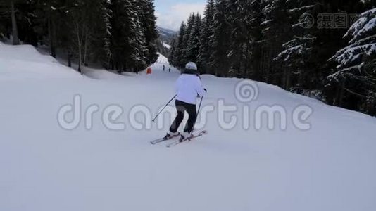 两名运动女滑雪运动员在山下的森林山坡上滑雪视频