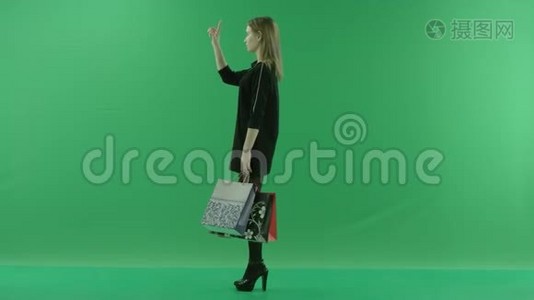 带包的年轻女性触摸增强现实中的虚拟屏幕，彩色关键绿色背景视频