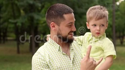 夏天，一个快乐的留胡子的父亲和他的儿子在公园里的肖像。视频
