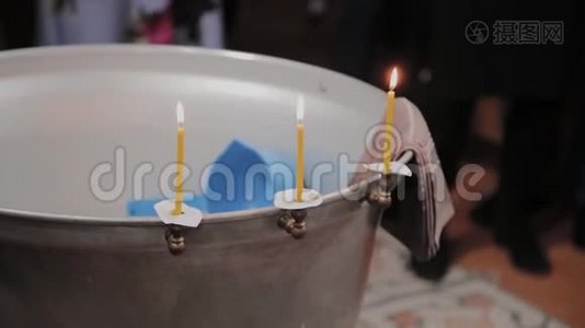 在东正教教堂用燃烧的蜡烛洗礼婴儿的字体。视频