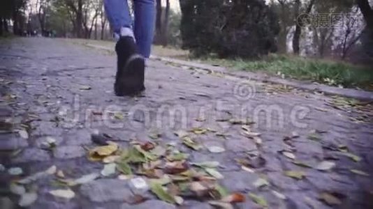 女人在公园里散步`特写镜头。 慢动作射击视频