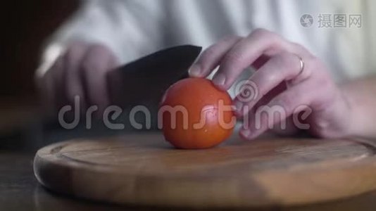 厨师慢动作地在一个酒吧的木板上切鲜红西红柿，做新鲜蔬菜沙拉，素食主义者视频