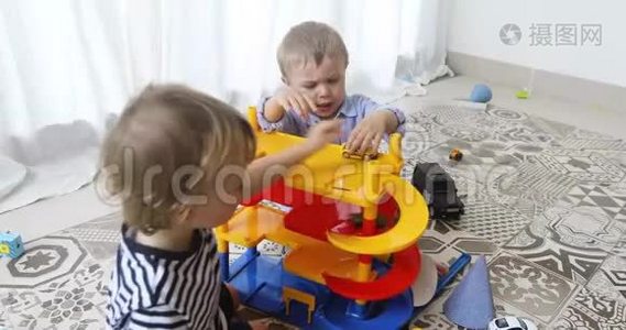 快乐的孩子在地板上玩玩具车视频
