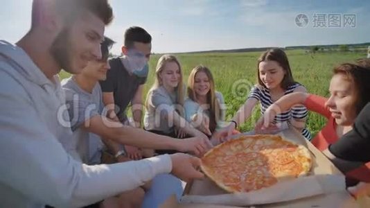 傍晚日落时分，孩子们的朋友们在户外挑选披萨。视频