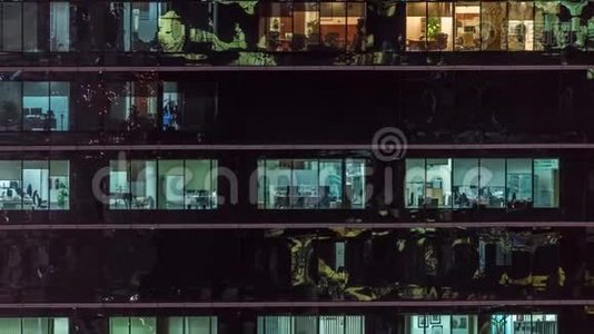 办公室摩天大楼在深夜外景，室内灯亮着，人们在夜间工作视频