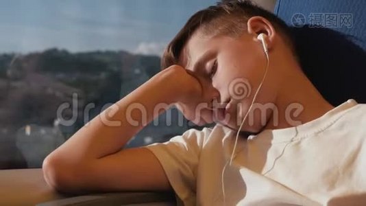 那个男孩在火车车厢的窗边睡觉。 这个男孩正在周游世界。 火车上的旅游男孩视频