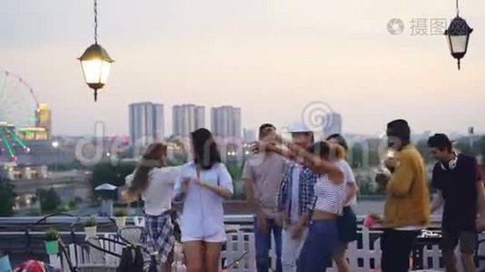 多种族的一群朋友正在屋顶跳舞，在夏天的晚上和DJ举行一个凉爽的聚会。 快乐的青年视频