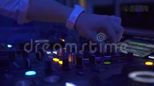男性手在DJ声音控制台混合家庭音乐在夜间聚会。 混合音乐和彩色光线的DJ控制器视频