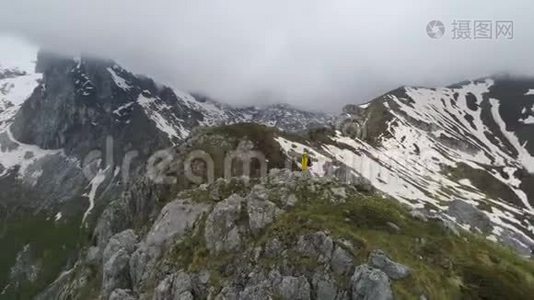 徒步旅行者站在山顶上，看着白雪皑皑的群山视频