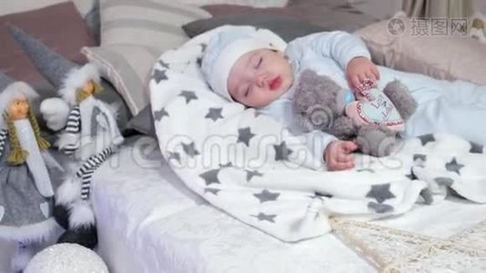 小男孩抱着玩具睡着了，一个男孩睡在父母的床上`房子里舒适的气氛，可爱的婴儿视频