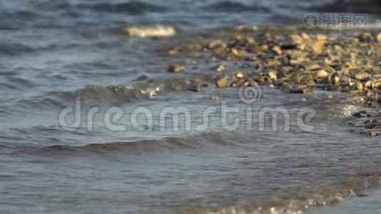 海的边缘，卵石滩，卵石滩.. 抽象背景。 卵石海滩，小卵石和海浪。 这就是视频