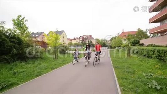 有孩子的父母骑自行车。 幸福的家庭一起度过时光。视频