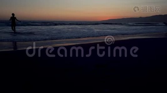 加利福尼亚太平洋海岸的日落，冲浪者和慢跑者都在做一项运动视频