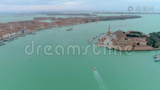 圣乔吉奥·马吉奥尔教堂空中无人机景观。 旅游船在圣乔治马吉奥尔教堂附近航行。 从这里看视频