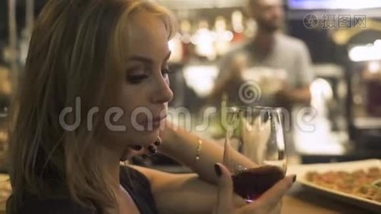 年轻女子手捧红酒杯在咖啡馆里。 在餐厅的活动派对上，女人品尝和喝红酒。视频