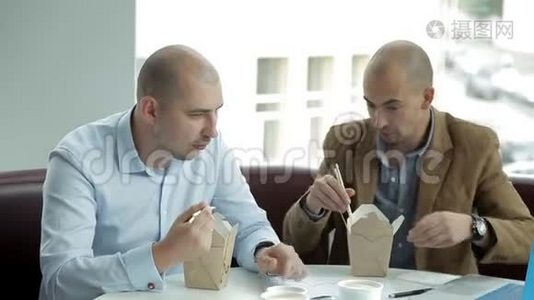 两个秃头男人在一家咖啡馆的午餐上讨论生意，吃面条。 中餐，商务中心视频