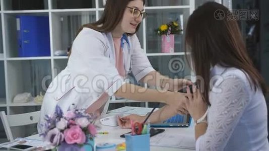 女医生测量病人在诊所办公室的压力，并正在写她的任务。视频
