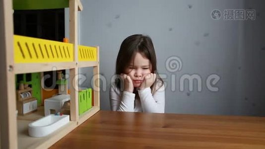 一个可爱的女孩在玩娃娃屋时感到困倦视频