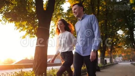 一对男女牵着手在秋城公园奔跑。 时髦的一对或穿商务服装的学生乐意视频