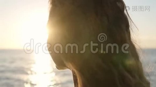 一个年轻的黑发女人站在阳光下的美丽肖像。 沉思地看着，享受着夏天视频