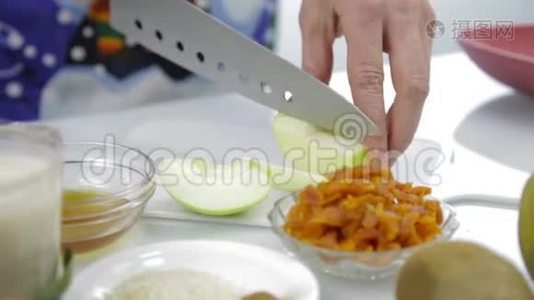 女人`手在厨房的砧板上切苹果。 烹饪健康食品视频
