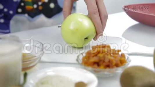 女人`厨房里的砧板上切了一个苹果。 烹饪健康食品视频
