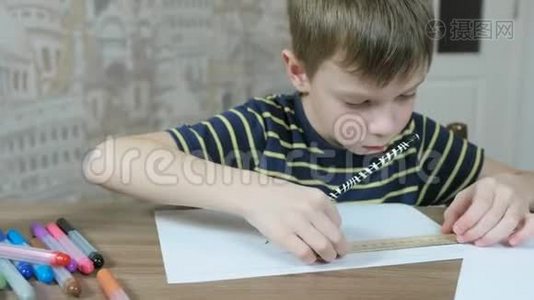 7岁的男孩穿着条纹t恤，用铅笔和尺子在纸上画均匀的线条。视频