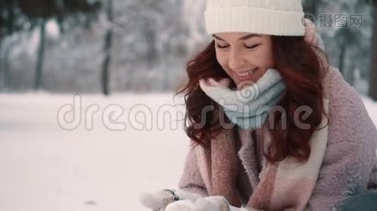 快乐的女人在白雪皑皑的树林里打雪球视频