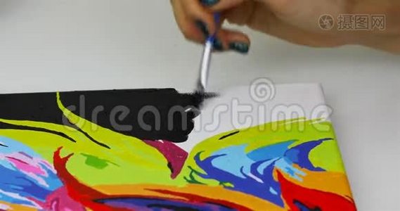 一个女孩在画布上用黑色颜料画画笔视频