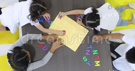 亚洲学生一起玩字母字母玩具。视频
