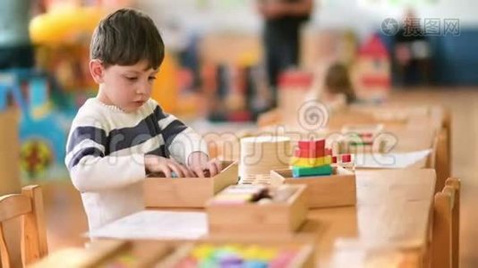 可爱的小男孩在幼儿园玩建筑玩具视频