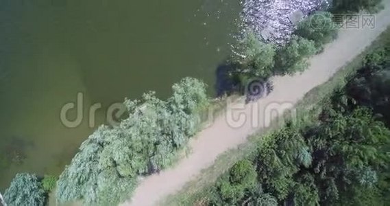 空中无人驾驶飞机俯瞰乡村湖泊，有渔夫桥和泥土砾石路视频