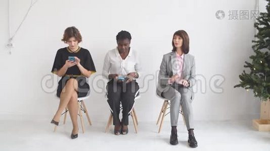 三个女孩坐在椅子上等待面试视频